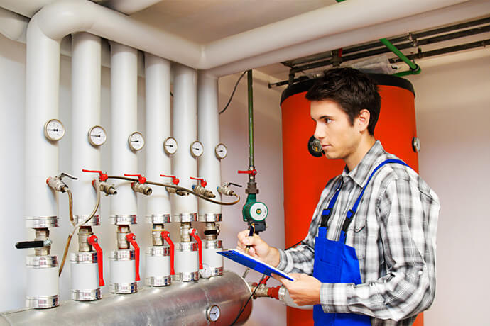 plumber examining unvented cylinder repair service in a London property
