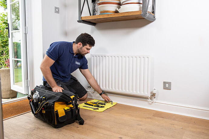 Book your powerflush service with My Plumber Plumber preparing for radiator power flush in a London home