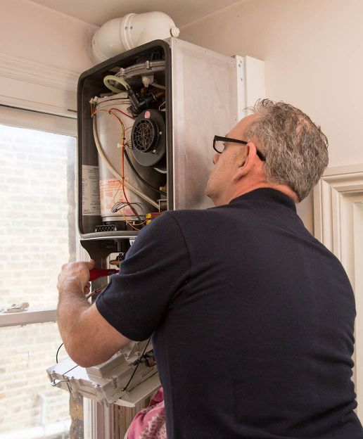 Quick and efficient boiler repair services in London Heating engineer repairing a boiler