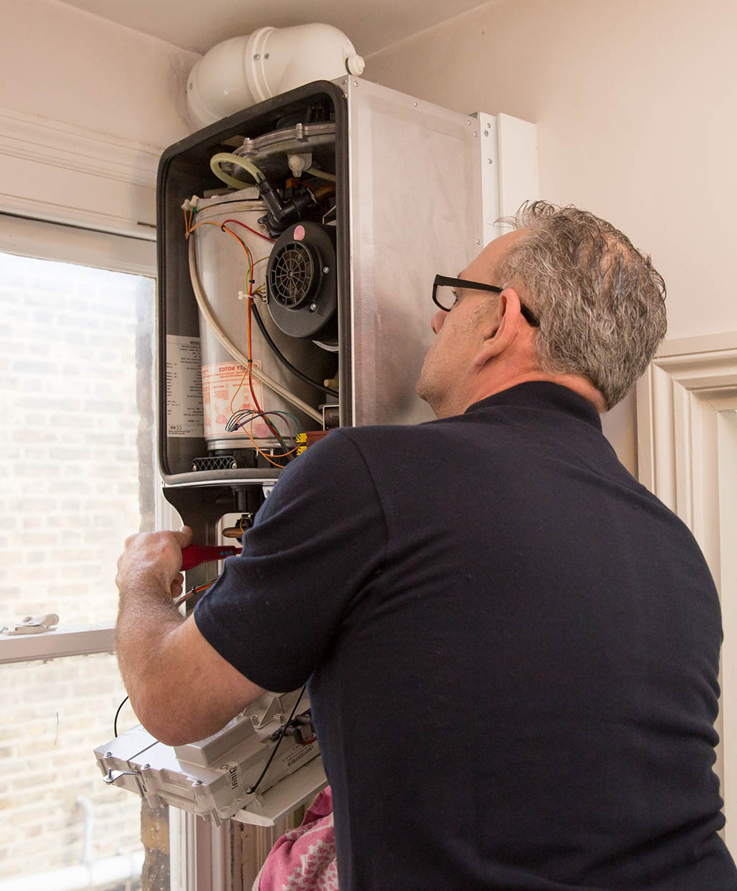 Heating engineer repairing a boiler