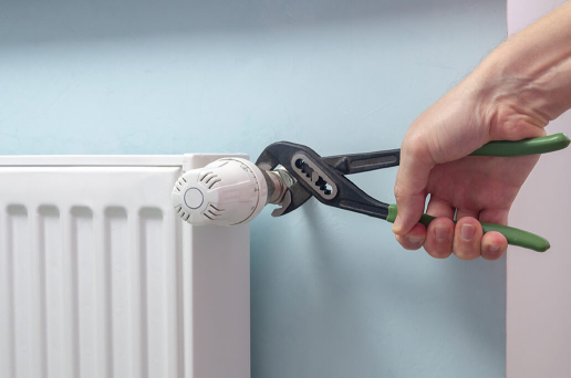 Book your expert radiator installation and repair in London with My Plumber Plumber installing a radiator in a London home