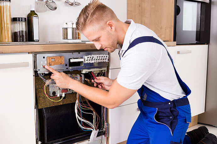 Book your gas cooker repair service with My Plumber Technician repairing a gas cooker in a London home