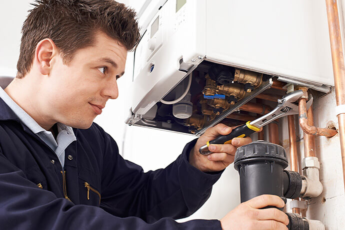 Plumber working on a central heating installation in a London property