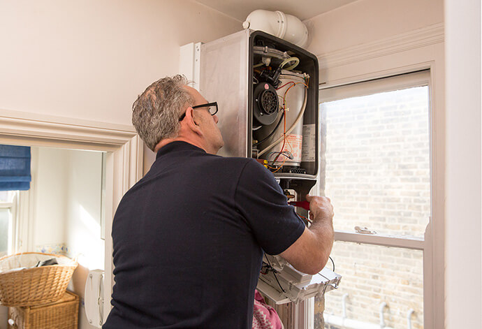 Reliable central heating repair service in London Plumber while repairing a boiler in London